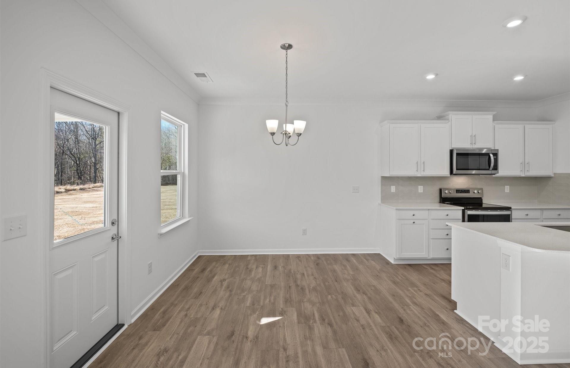 11416 Glasden Road, Unit 511 Charlotte, NC 28278 - Photo 5 of 13 a kitchen with cabinets wooden floor and a window