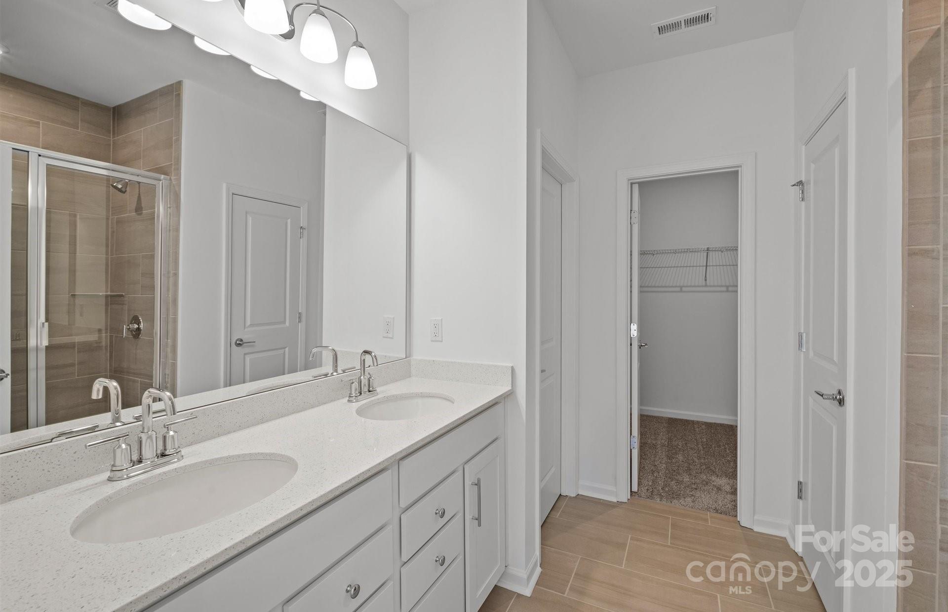 11416 Glasden Road, Unit 511 Charlotte, NC 28278 - Photo 7 of 13 a bathroom with double vanity sink and a mirror