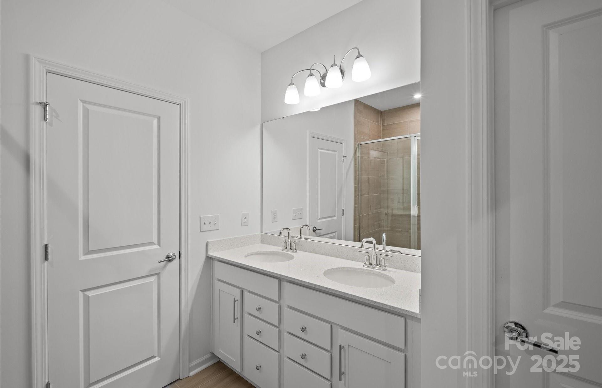 11416 Glasden Road, Unit 511 Charlotte, NC 28278 - Photo 8 of 13 a bathroom with a double vanity sink and a mirror