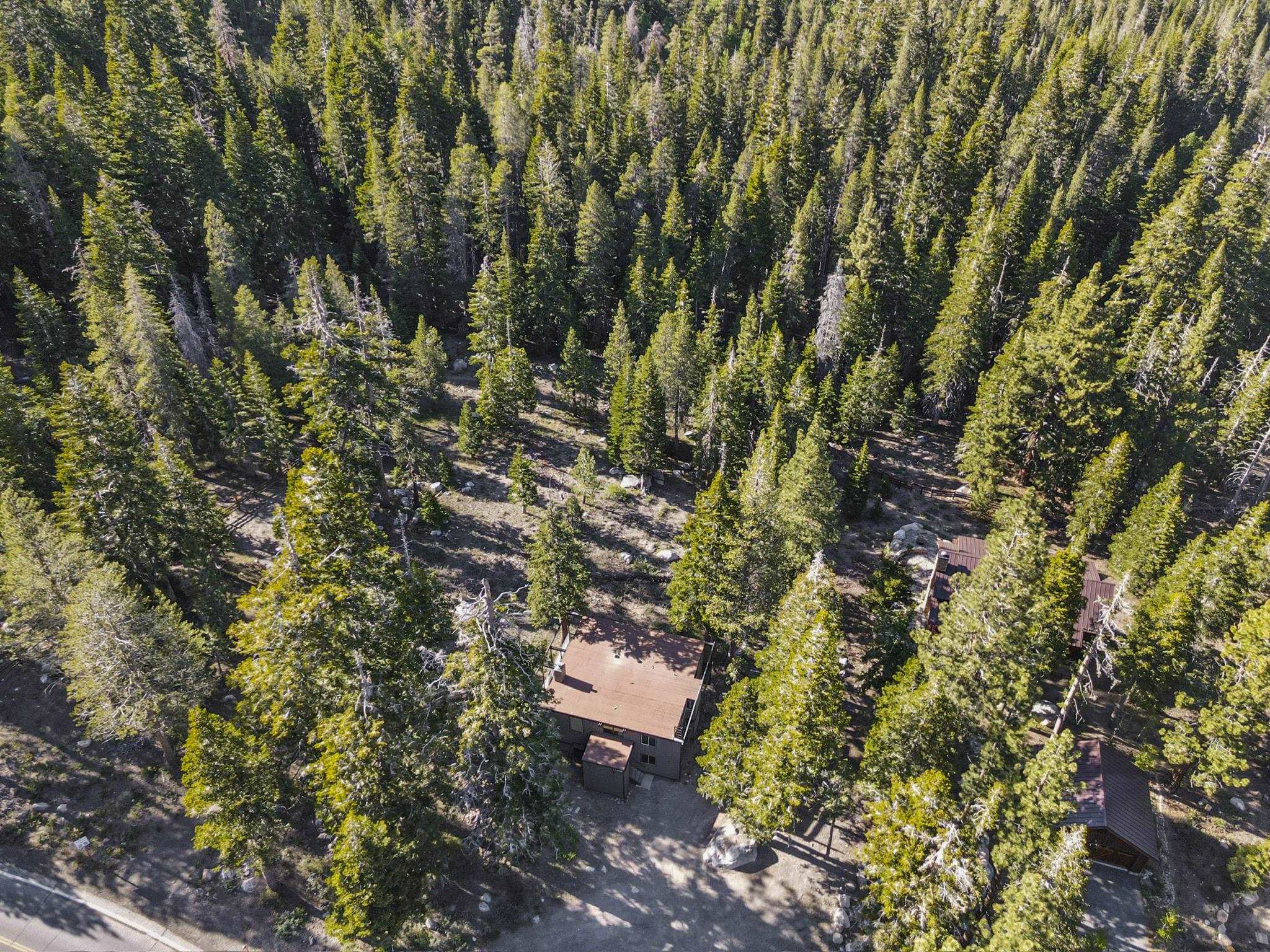 2570 Old Mammoth Road Mammoth Lakes, CA 93546 - Photo 35 of 39 Wooded setting surrounding a multi-level structure with a brown roof