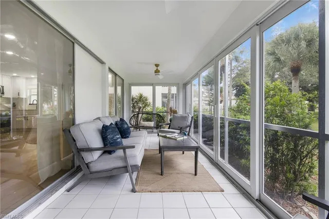 a living room with furniture and a floor to ceiling window