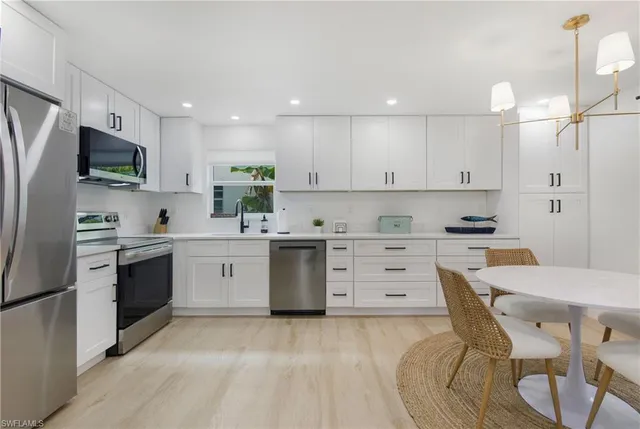 a kitchen with white cabinets stainless steel appliances and sink