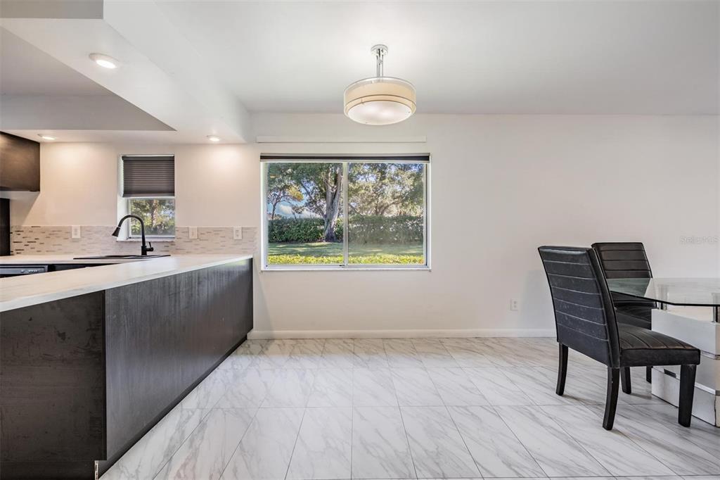 2292 Oak Neck Road, Unit A Clearwater, FL 33763 - Photo 13 of 37 a kitchen with a wooden table and chairs