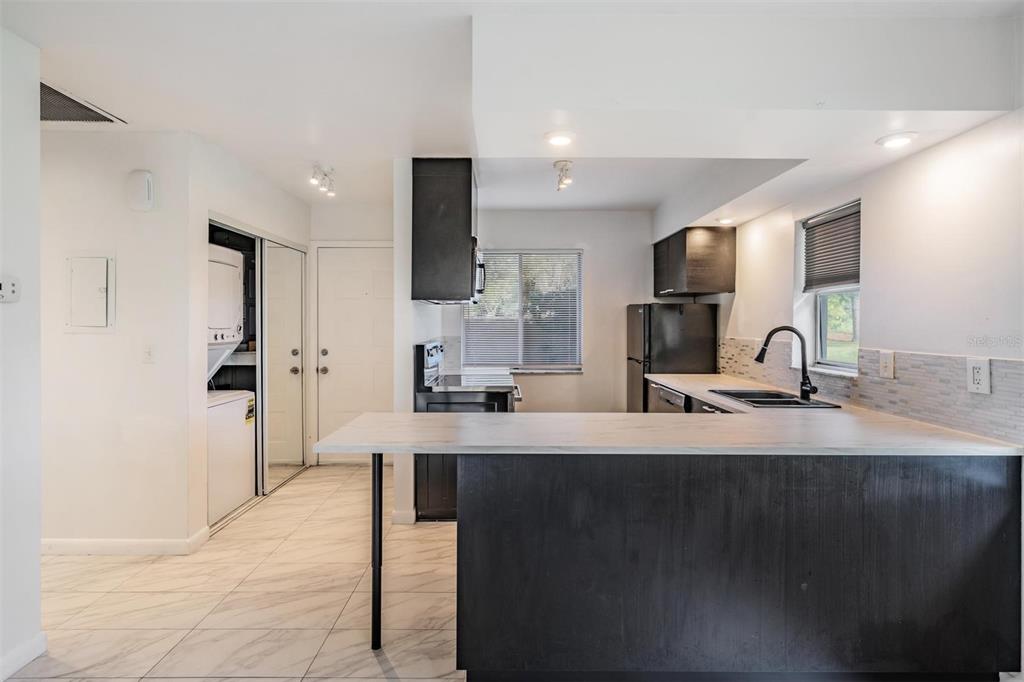 2292 Oak Neck Road, Unit A Clearwater, FL 33763 - Photo 4 of 37 a kitchen with kitchen island a sink appliances and a counter top space