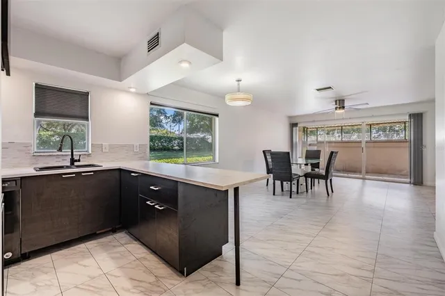 a kitchen with a sink and chairs