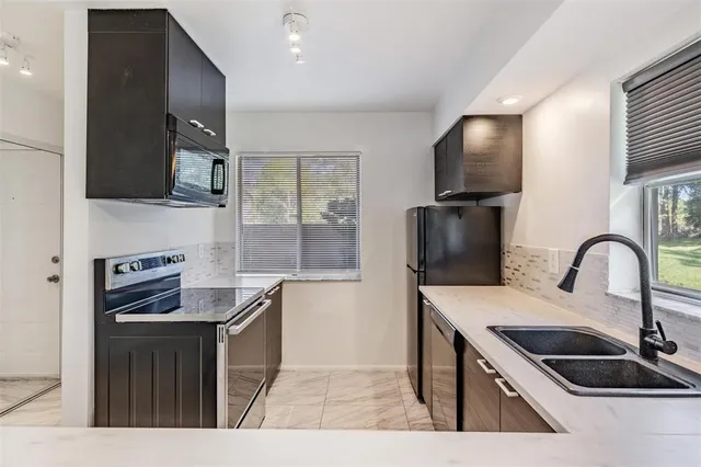 a kitchen with granite countertop a sink and a stove top oven with wooden floor