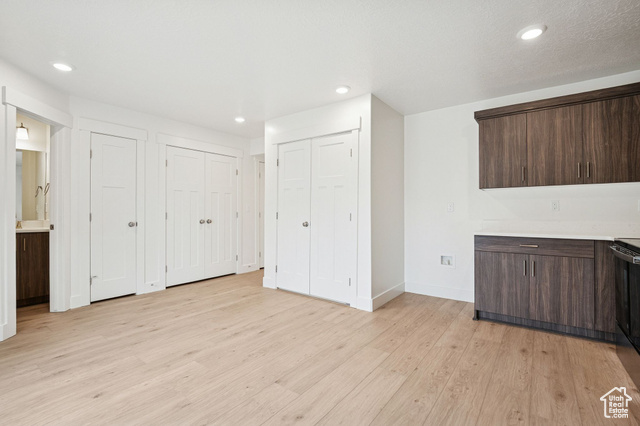 1615 North Angel Street, Unit H Layton, UT 84041 - Photo 20 of 55 Bar with dark brown cabinets, light wood-type flooring, recessed lighting, black range oven, and modern cabinets