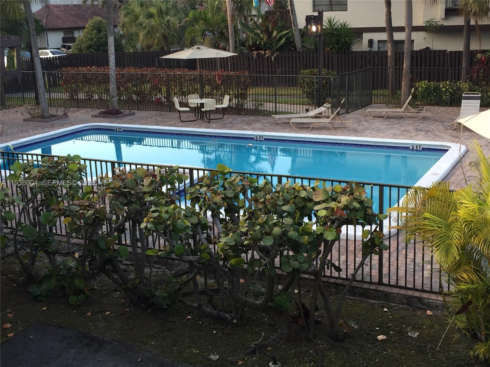 13253 Southwest 111th Terrace, Unit 3 Miami, FL 33186 - Photo 11 of 48 a view of a swimming pool with a patio and fire pit