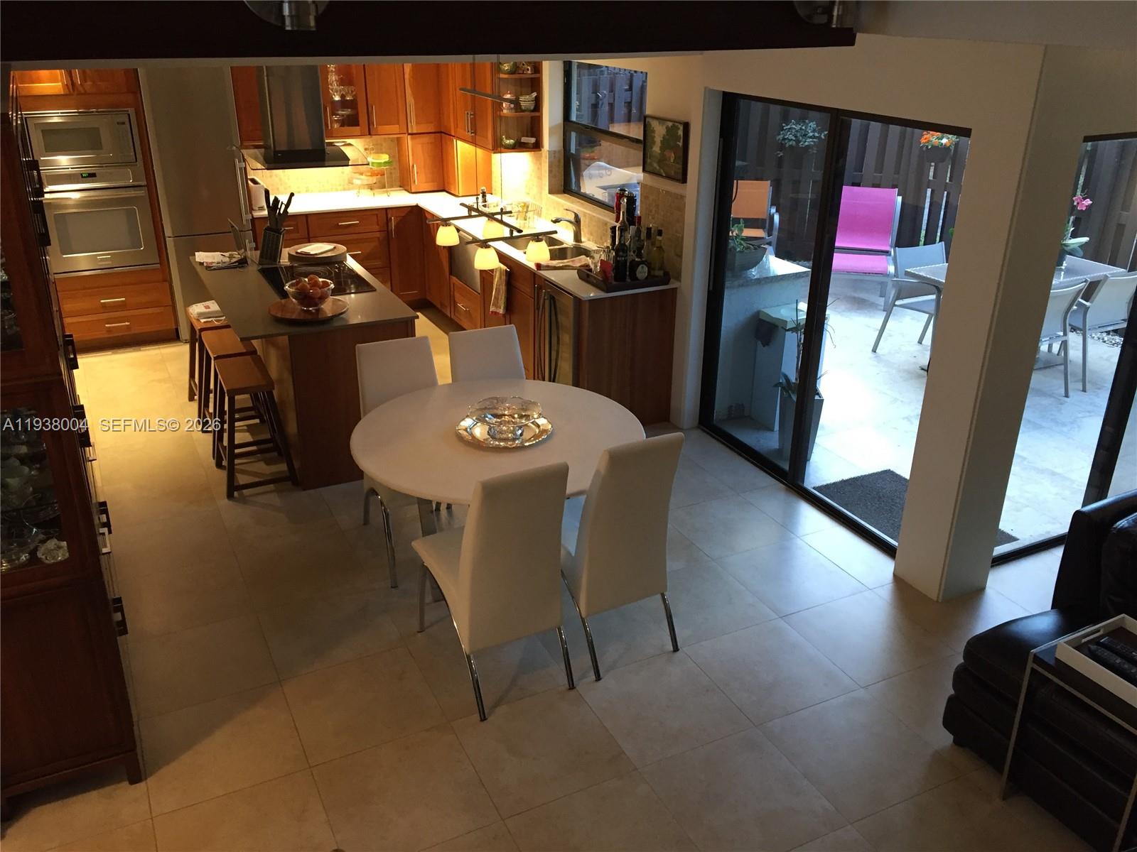 13253 Southwest 111th Terrace, Unit 3 Miami, FL 33186 - Photo 22 of 48 a view of a dining room with furniture and chandelier