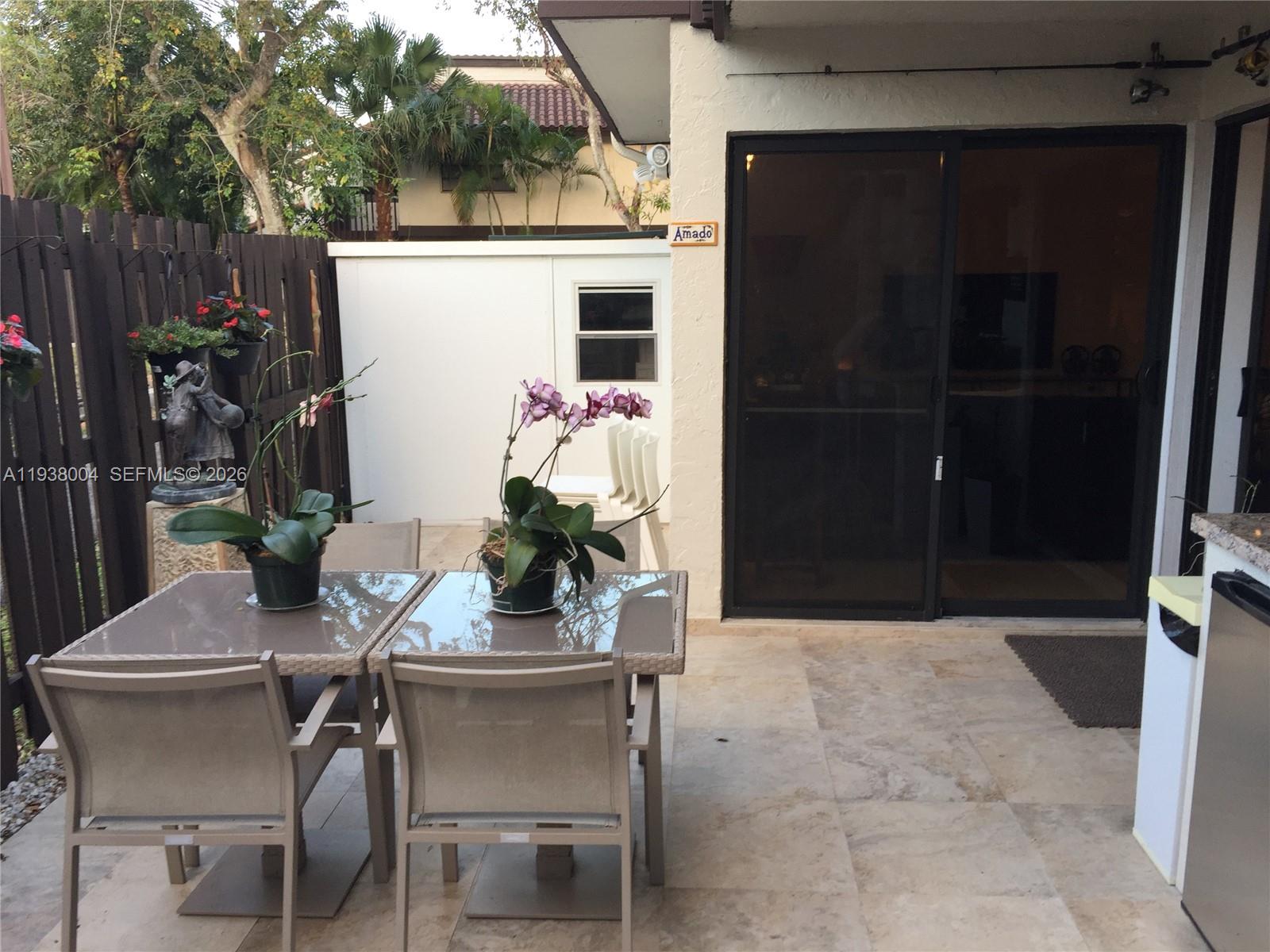 13253 Southwest 111th Terrace, Unit 3 Miami, FL 33186 - Photo 32 of 48 a backyard of a house with table and chairs