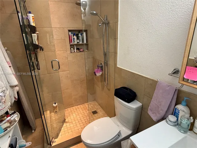 a white toilet sitting next to a bathroom sink and a mirror