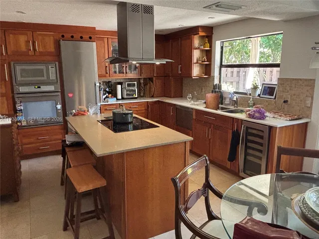 a kitchen with stainless steel appliances a table chairs and a refrigerator