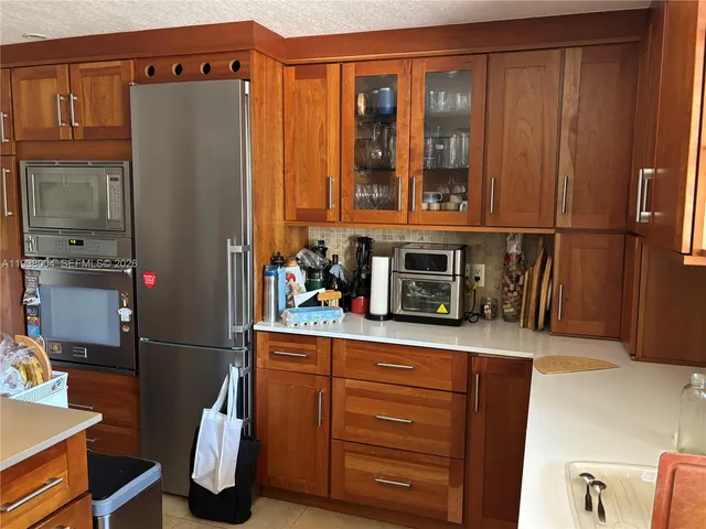 a kitchen with stainless steel appliances granite countertop a refrigerator and a stove