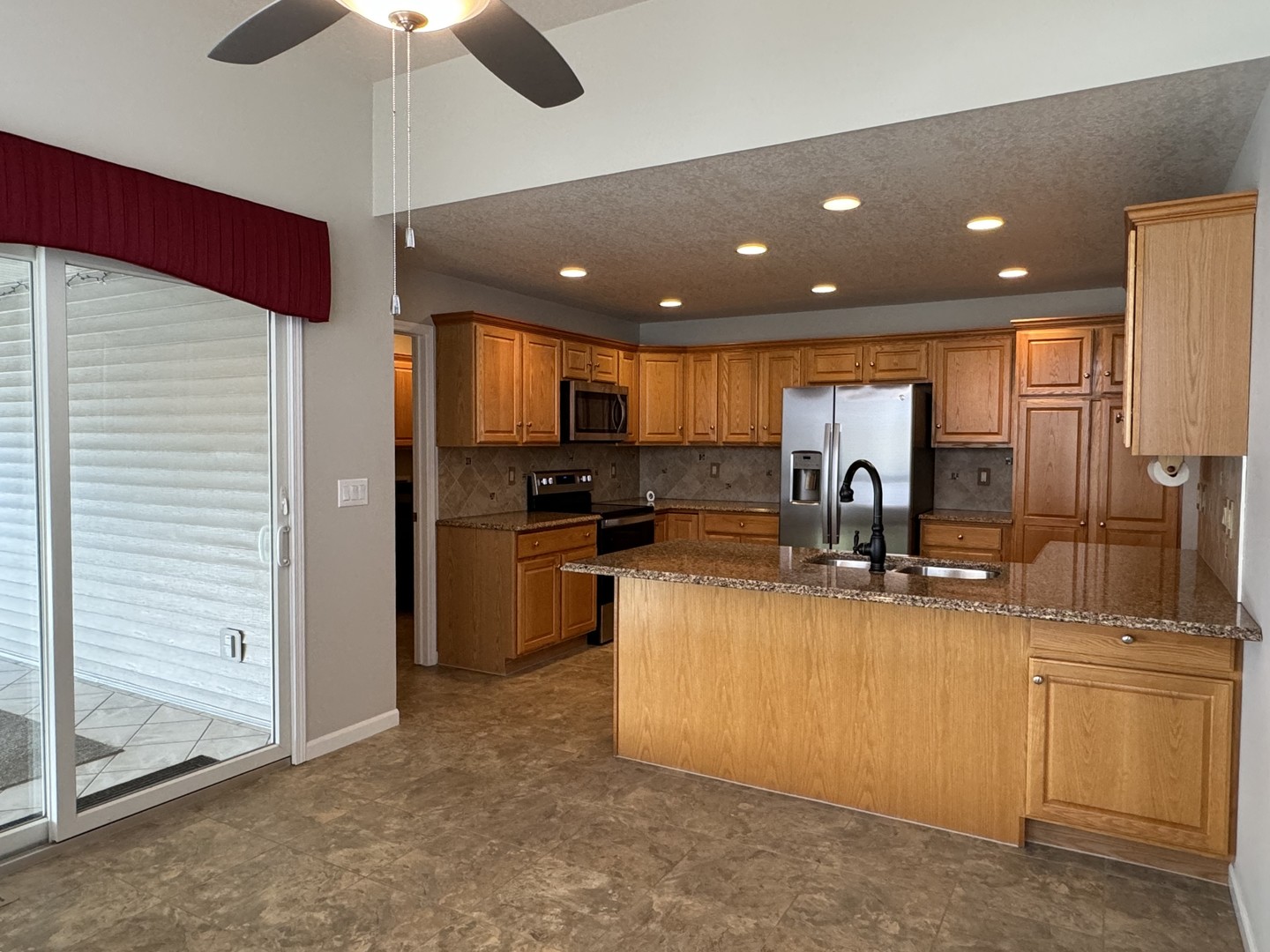 453 East Kay Street Herscher, IL 60941 - Photo 12 of 54 a kitchen with stainless steel appliances kitchen island granite countertop a refrigerator a stove and a sink with wooden floor