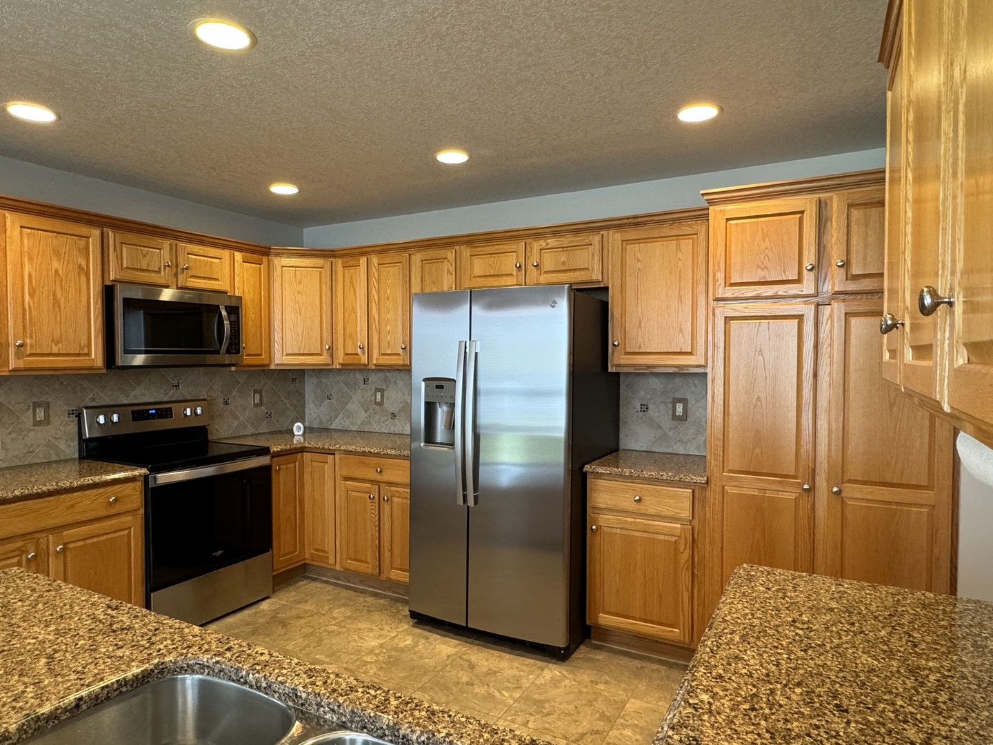 453 East Kay Street Herscher, IL 60941 - Photo 15 of 54 a kitchen with stainless steel appliances granite countertop a refrigerator a stove a sink and a refrigerator with wooden floor