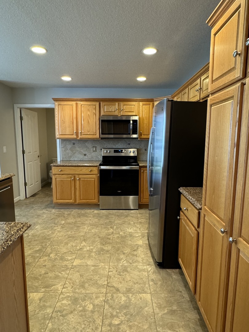 453 East Kay Street Herscher, IL 60941 - Photo 17 of 54 a kitchen with stainless steel appliances granite countertop a refrigerator a stove and a sink