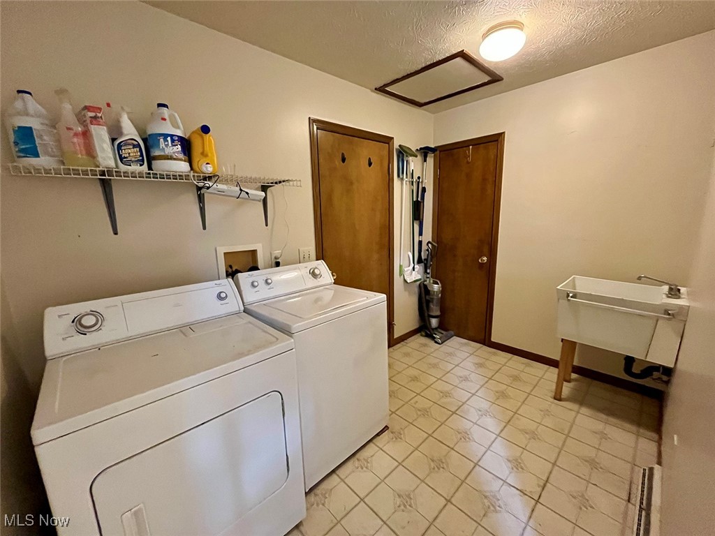 5295 Deer Road Southwest Bowerston, OH 44695 - Photo 13 of 39 Laundry room with a sink, a textured ceiling, washing machine and dryer, attic access, and laundry area