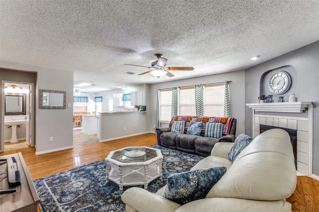 a kitchen with granite countertop a stove a sink a dining table and chairs with wooden floor