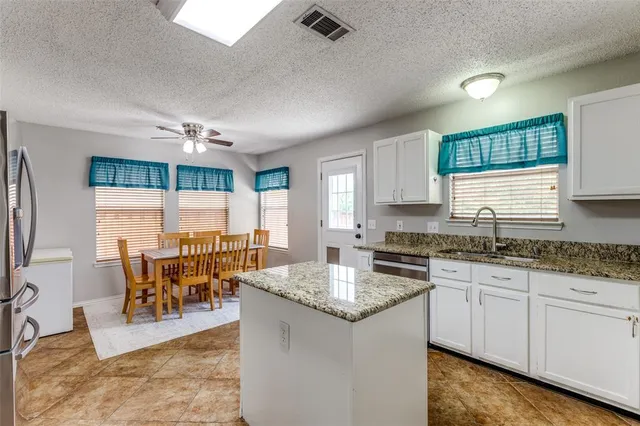 a kitchen with stainless steel appliances granite countertop a stove sink and cabinets