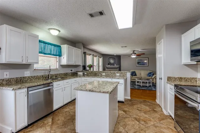 a kitchen with stainless steel appliances granite countertop a refrigerator stove microwave and sink