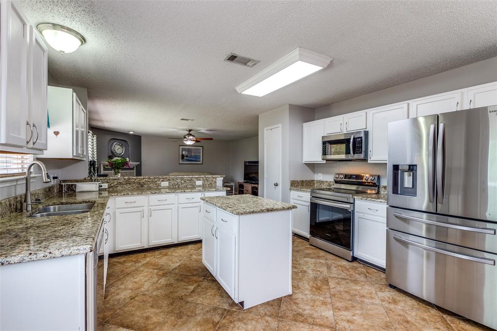 1017 Lake Trail Drive Little Elm, TX 75068 - Photo 18 of 35 a kitchen with stainless steel appliances granite countertop a refrigerator stove microwave and sink