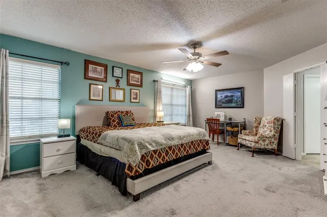 a spacious bedroom with a bed and a chandelier
