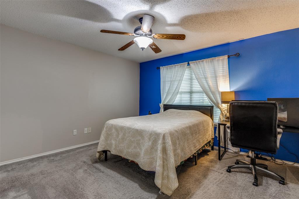 1017 Lake Trail Drive Little Elm, TX 75068 - Photo 30 of 35 a bedroom with a bed and a chandelier