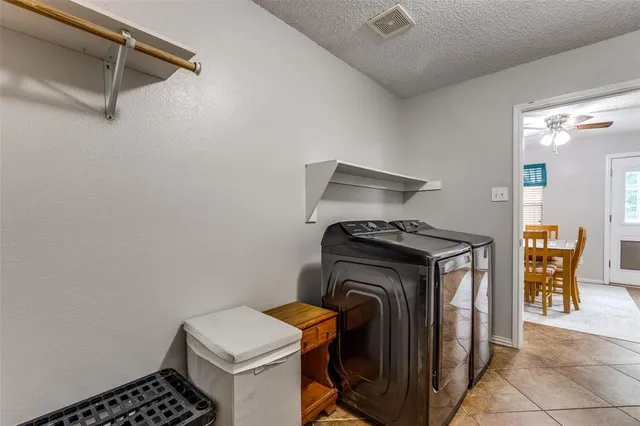 a view of backyard with potted plants and wooden fence