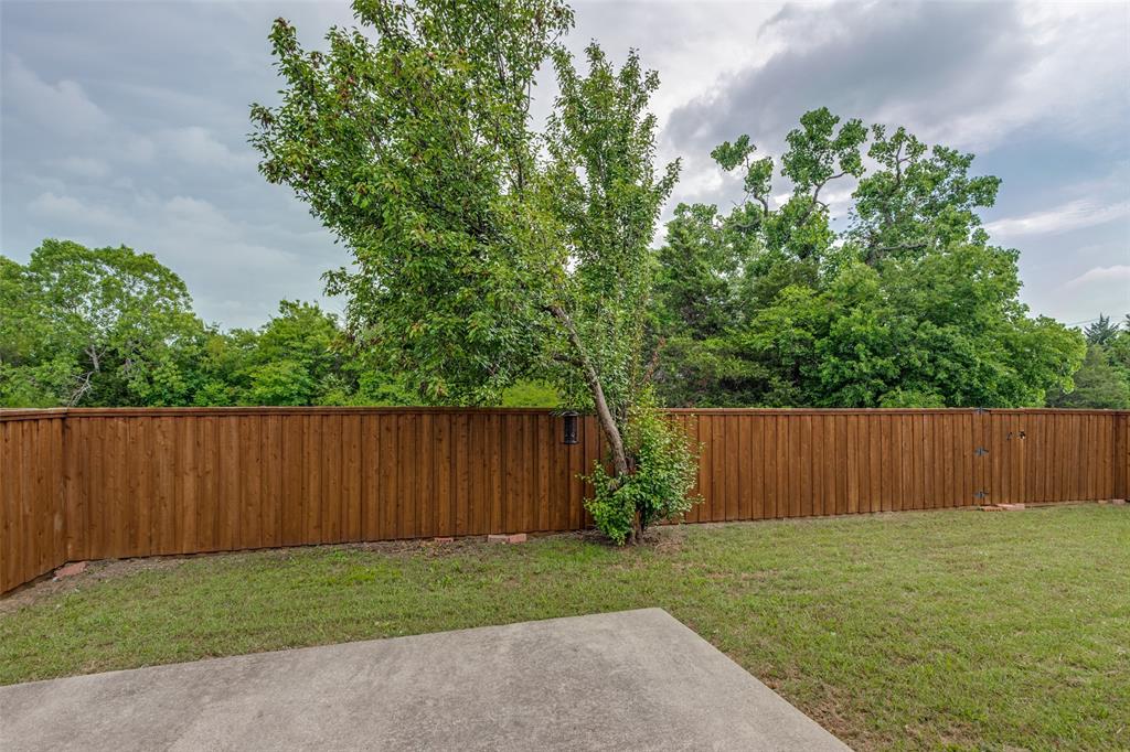 1017 Lake Trail Drive Little Elm, TX 75068 - Photo 33 of 35 a view of backyard with potted plants and wooden fence