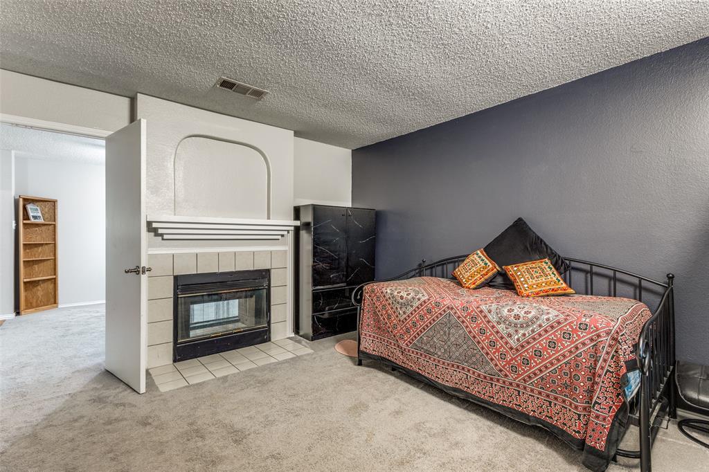 1017 Lake Trail Drive Little Elm, TX 75068 - Photo 8 of 35 a bedroom with a bed and a fireplace