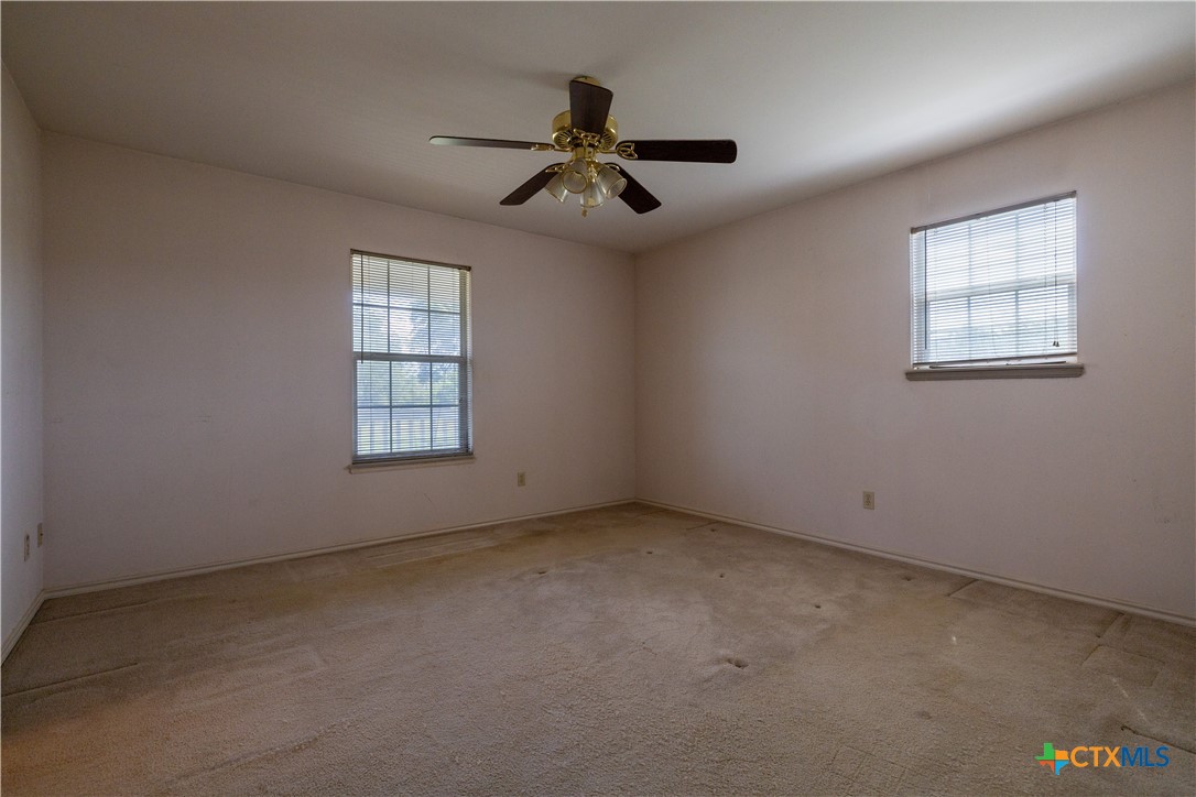 199 Sunset Trail Luling, TX 78648 - Photo 11 of 34 an empty room with windows and fan