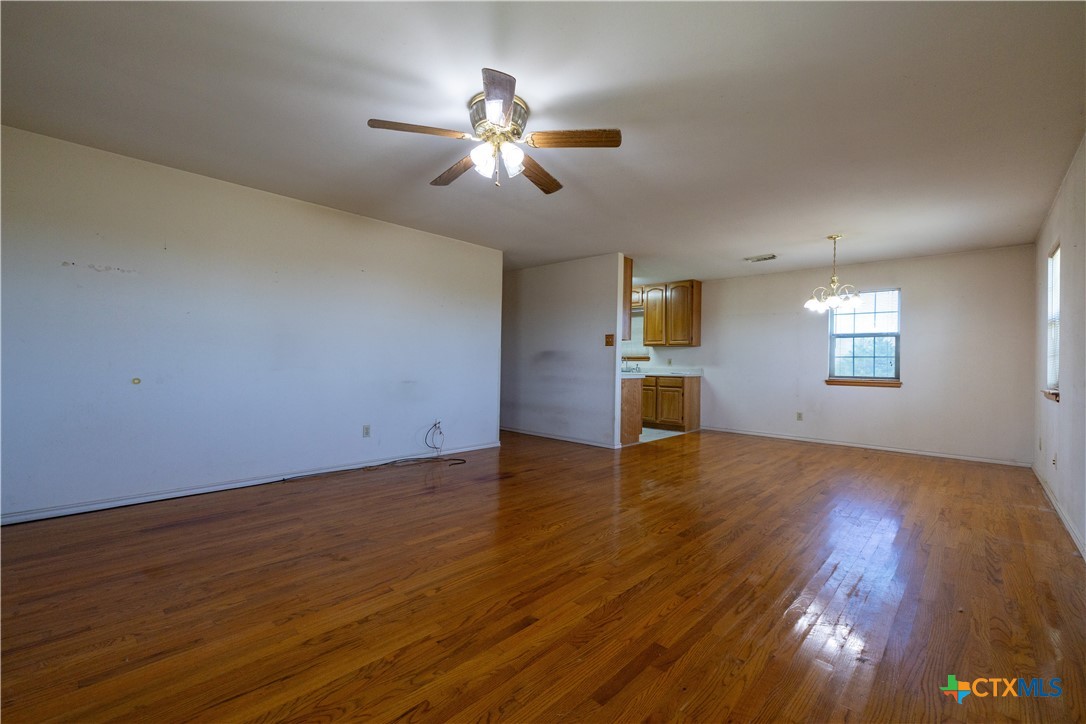 199 Sunset Trail Luling, TX 78648 - Photo 6 of 34 a view of an empty room with window and wooden floor