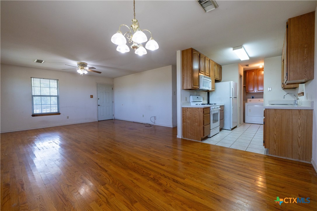 199 Sunset Trail Luling, TX 78648 - Photo 7 of 34 a view of a kitchen with wooden floor and a refrigerator