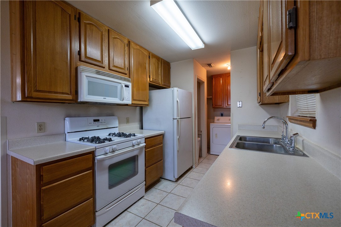 199 Sunset Trail Luling, TX 78648 - Photo 8 of 34 a kitchen with stainless steel appliances granite countertop a stove a refrigerator and a microwave