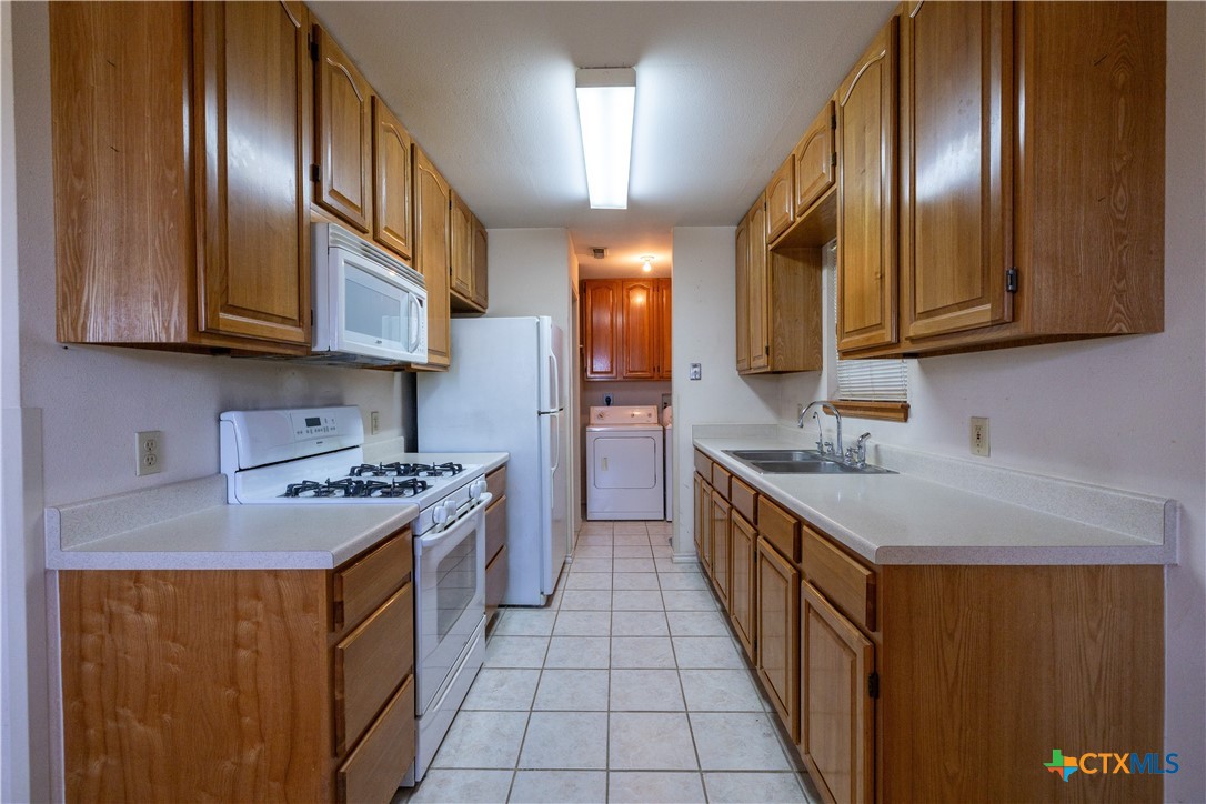 199 Sunset Trail Luling, TX 78648 - Photo 9 of 34 a kitchen with stainless steel appliances granite countertop a stove top oven a sink dishwasher and cabinets