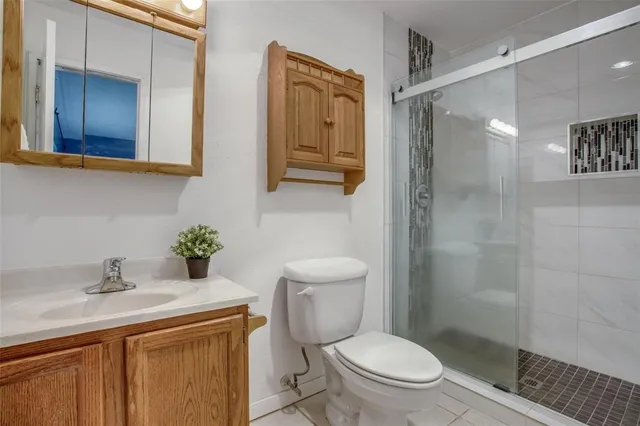 a bathroom with a granite countertop toilet sink and shower