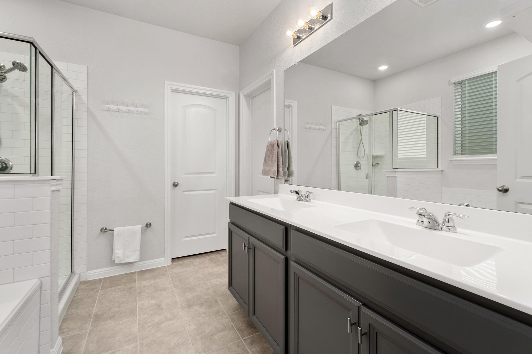 1008 Testoa Cove Hutto, TX 78634 - Photo 14 of 26 Bathroom featuring double vanity, a stall shower, and light tile patterned floors