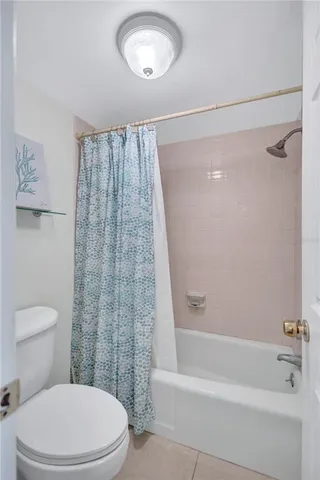 a white toilet sitting next to a bath tub