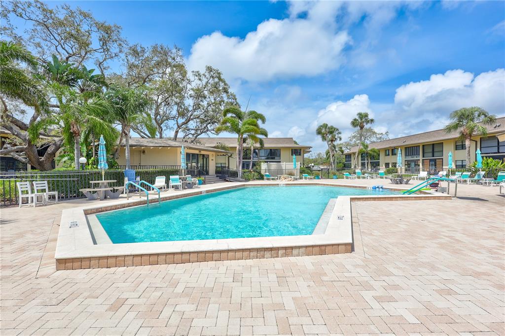 12300 Vonn Road, Unit 1102 Largo, FL 33774 - Photo 26 of 45 a view of a white house with a yard table and chairs