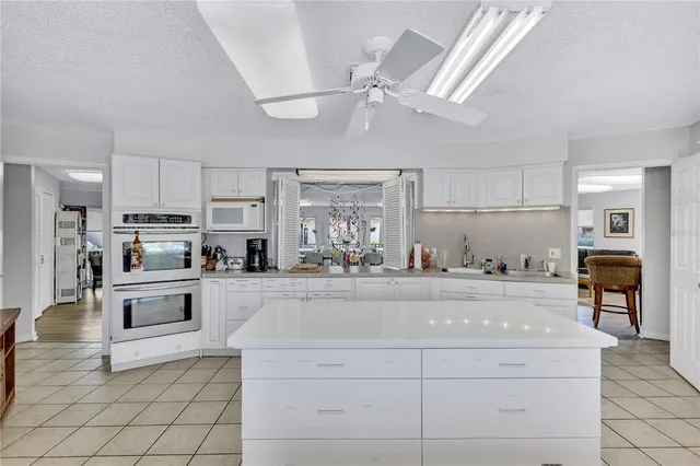 a kitchen with stainless steel appliances kitchen island granite countertop a refrigerator oven a sink and dishwasher