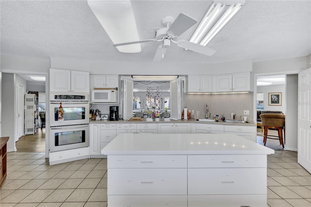 12300 Vonn Road, Unit 1102 Largo, FL 33774 - Photo 38 of 45 a kitchen with stainless steel appliances kitchen island granite countertop a refrigerator oven a sink and dishwasher