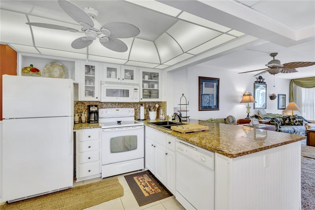 12300 Vonn Road, Unit 1102 Largo, FL 33774 - Photo 4 of 45 a kitchen with stainless steel appliances granite countertop a sink and a refrigerator