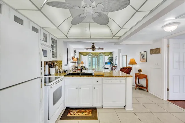 a kitchen with stainless steel appliances a stove a sink and white cabinets