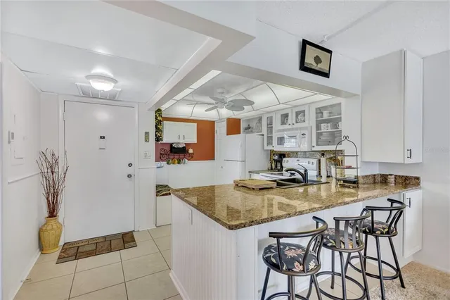 a kitchen with stainless steel appliances granite countertop a sink and a refrigerator