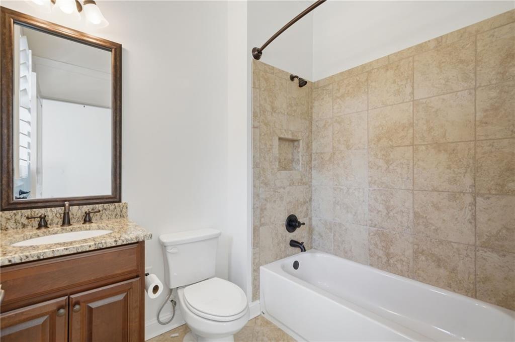 655 Hemlock Trail Canton, GA 30114 - Photo 18 of 58 a bathroom with a granite countertop toilet a sink and a bathtub
