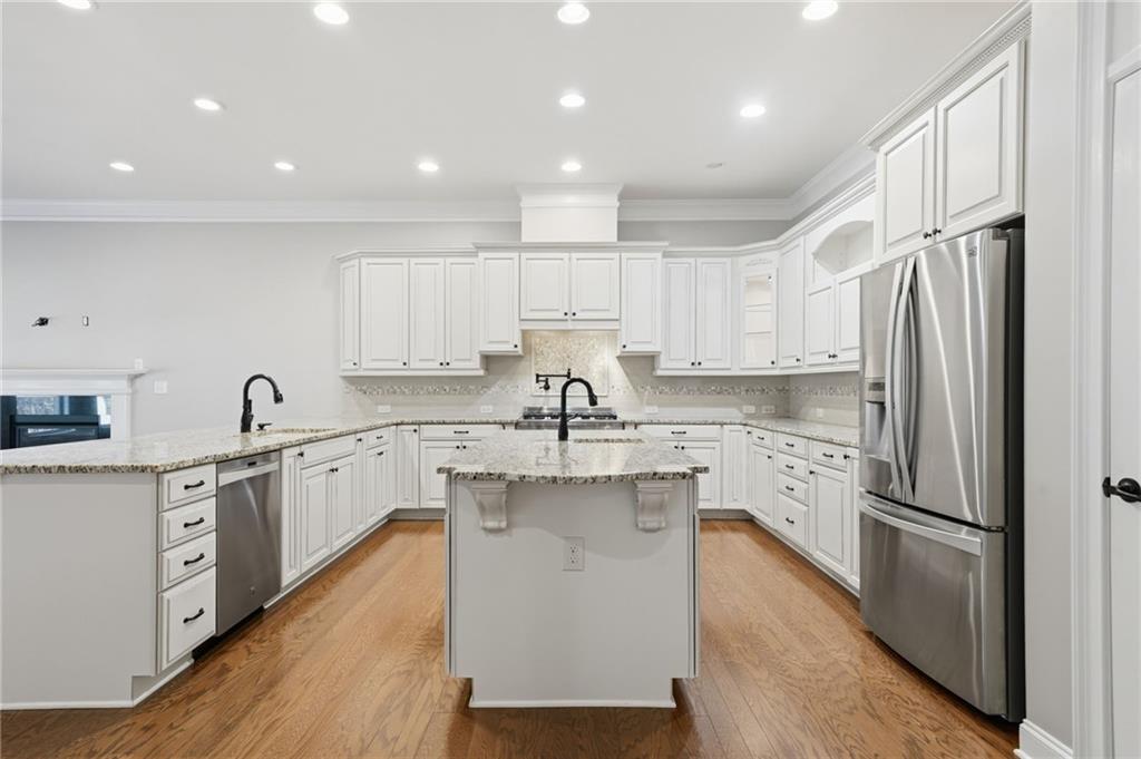 655 Hemlock Trail Canton, GA 30114 - Photo 27 of 58 a kitchen with white cabinets and stainless steel appliances