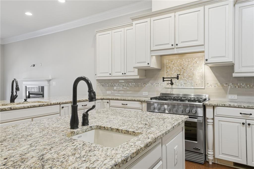 655 Hemlock Trail Canton, GA 30114 - Photo 31 of 58 a kitchen with granite countertop a sink stainless steel appliances and white cabinets