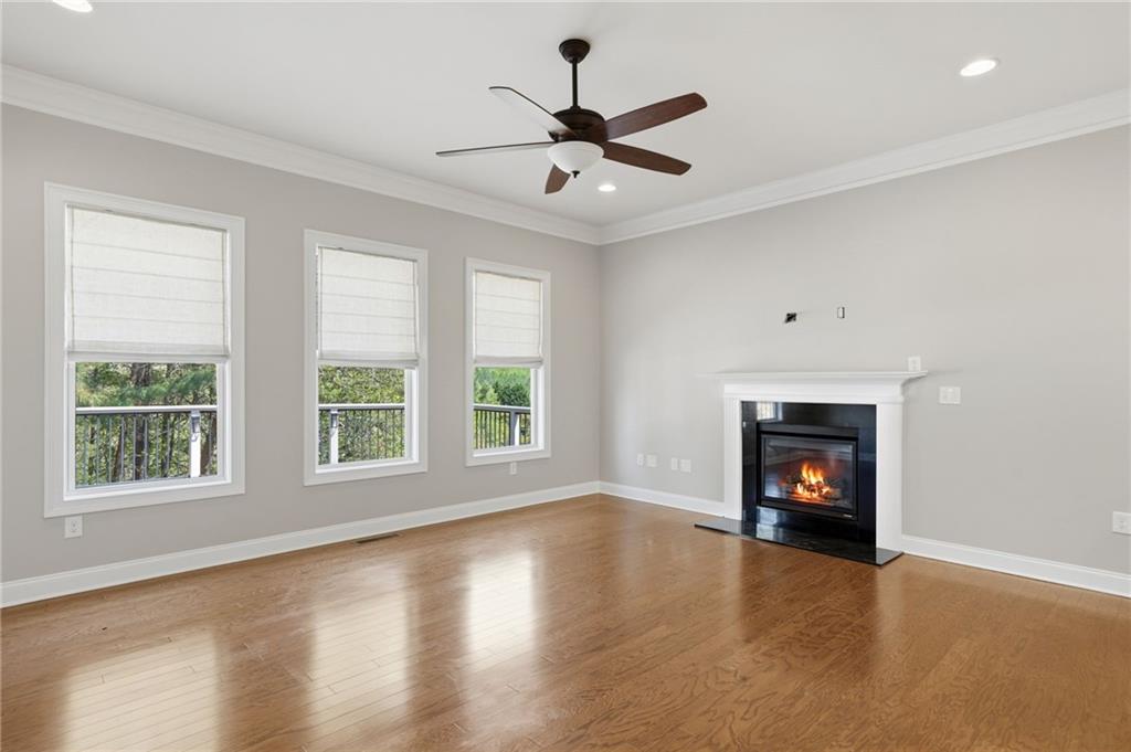 655 Hemlock Trail Canton, GA 30114 - Photo 32 of 58 an empty room with windows fireplace and a ceiling fan