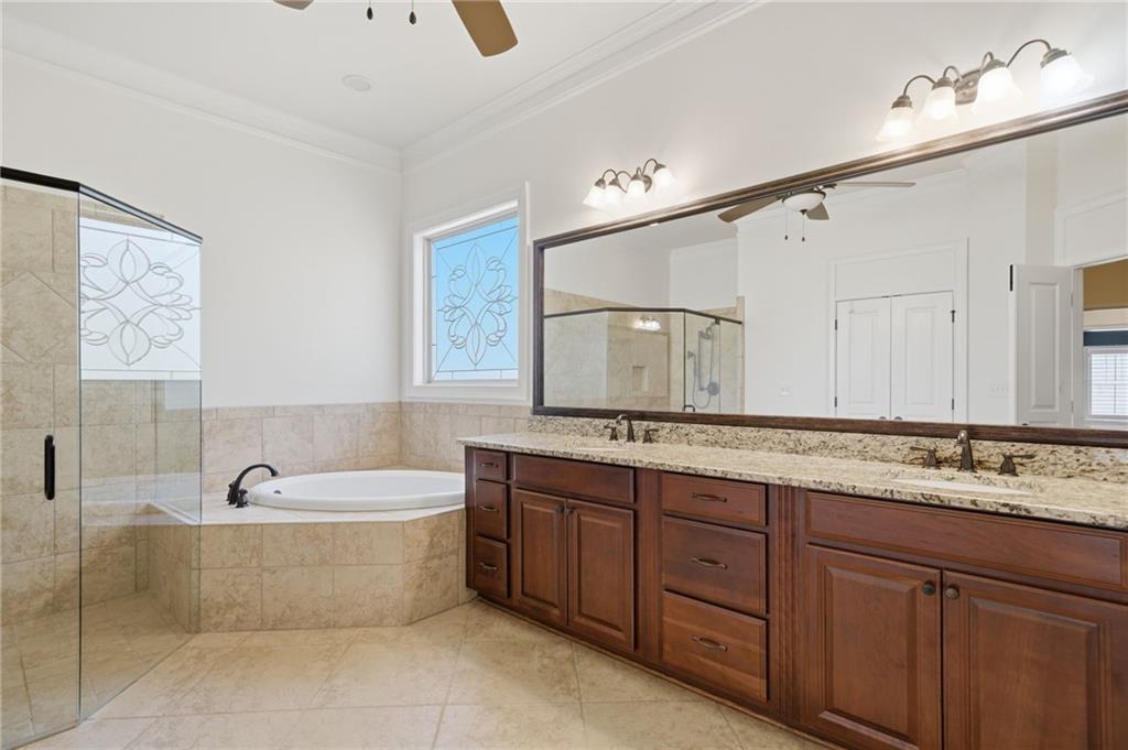 655 Hemlock Trail Canton, GA 30114 - Photo 36 of 58 a bathroom with a tub a sink double vanity and mirror