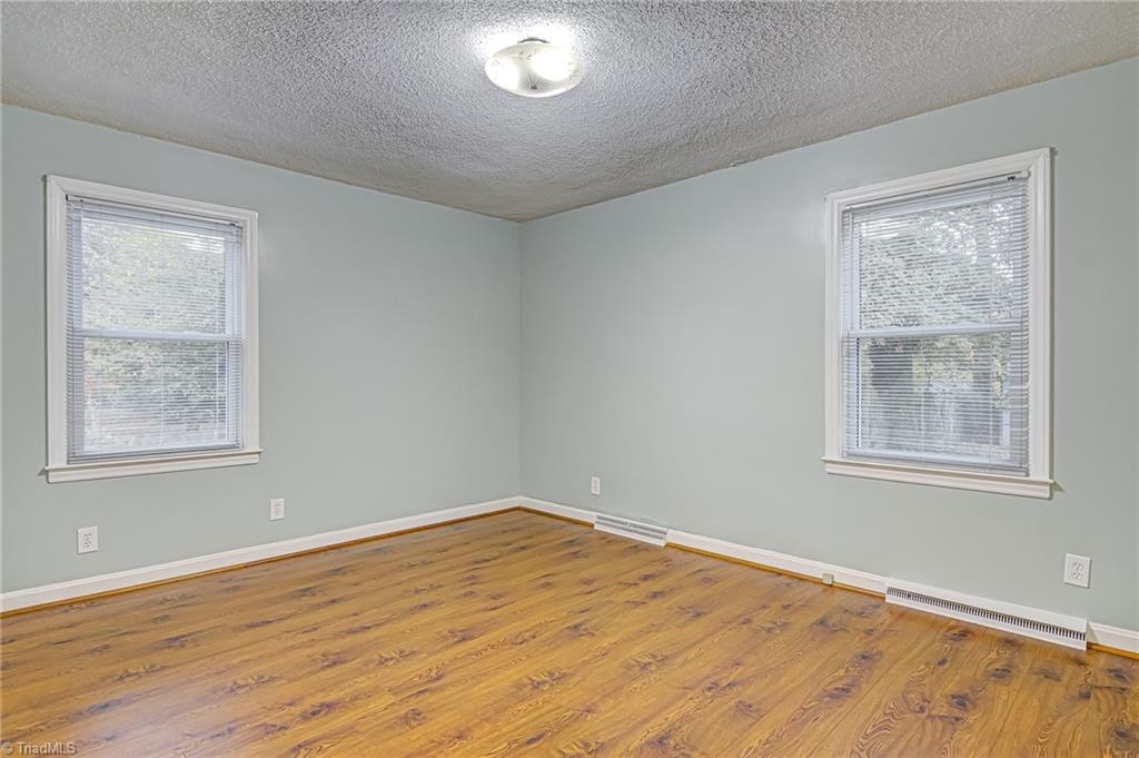 1145 Tabor Street High Point, NC 27262 - Photo 17 of 24 Large primary bedroom also feature large windows and laminate flooring.